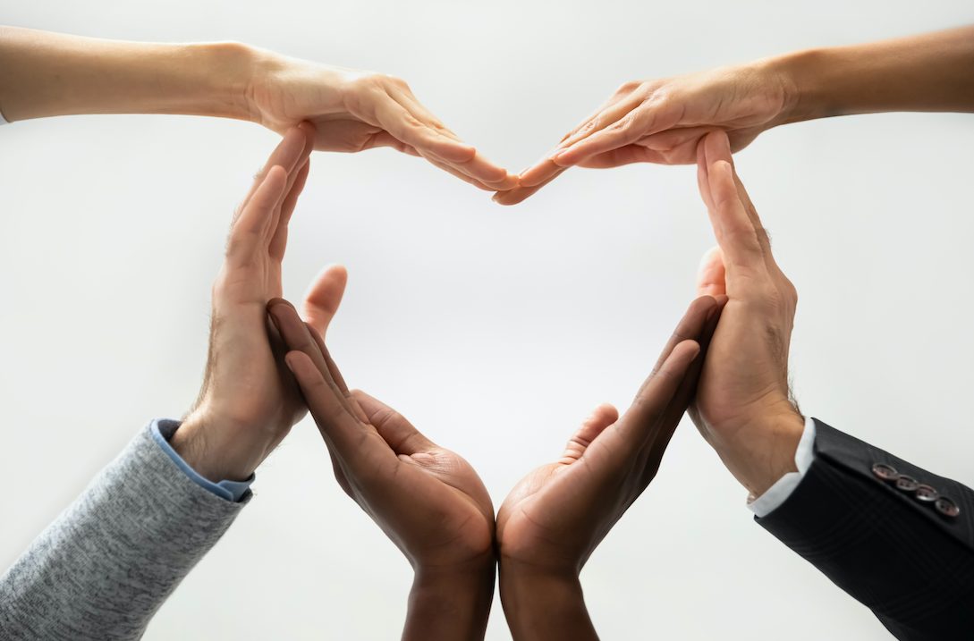 Hands of different people joining together to form a heart